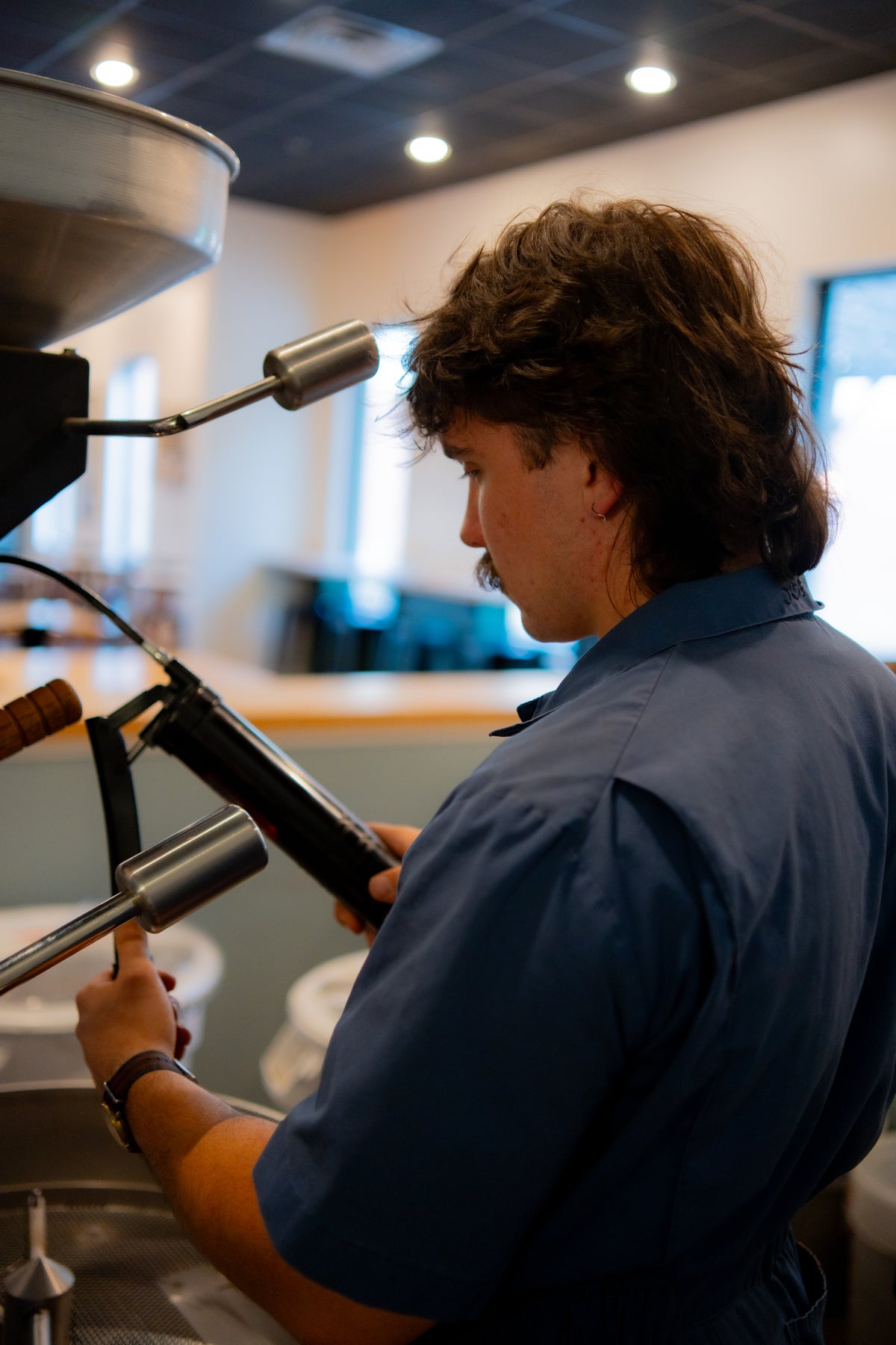 Coffee technician Jacob Bristol servicing a coffee roaster component