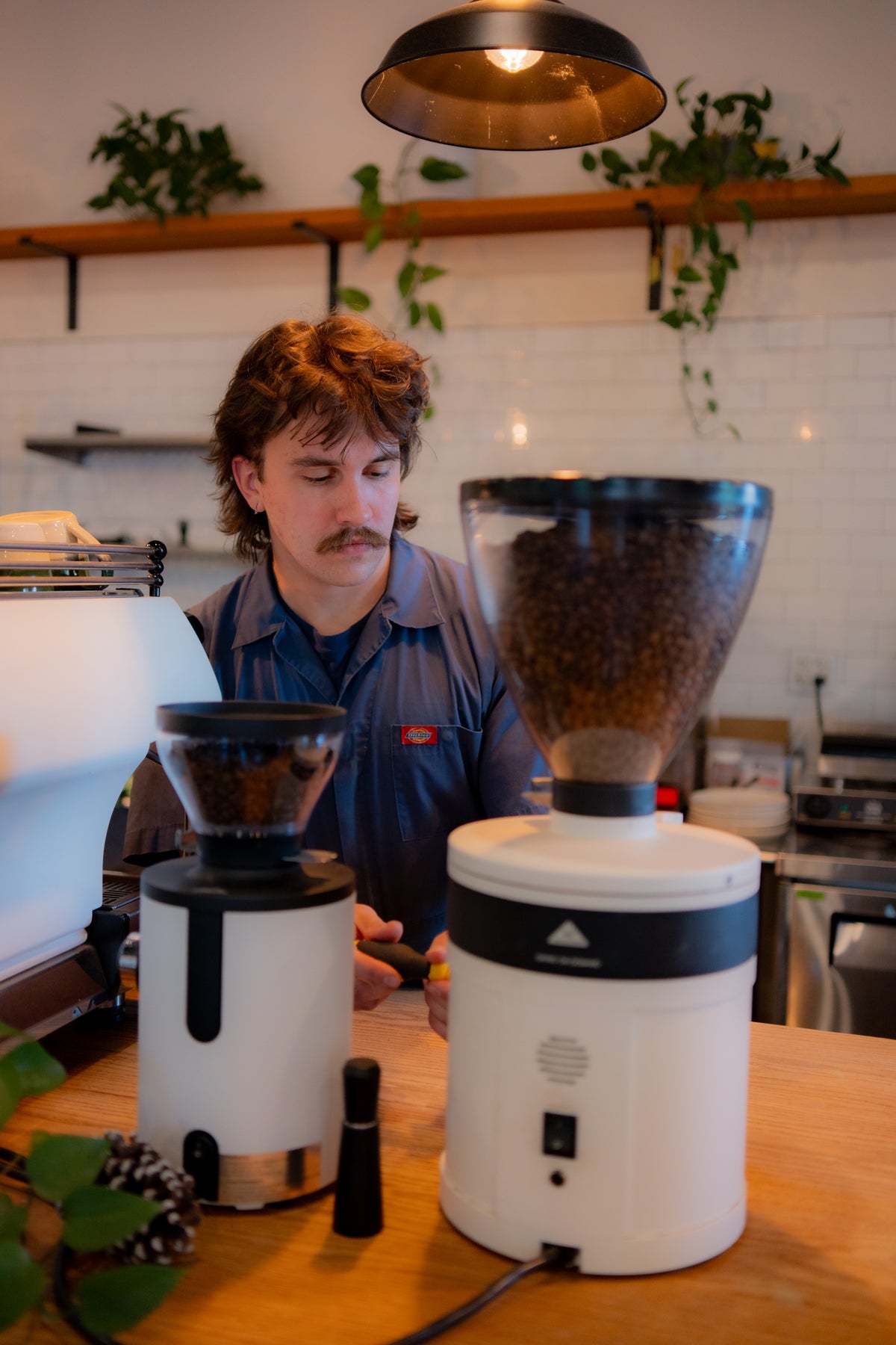 Technician servicing a coffee grinder during a cafe maintenance visit