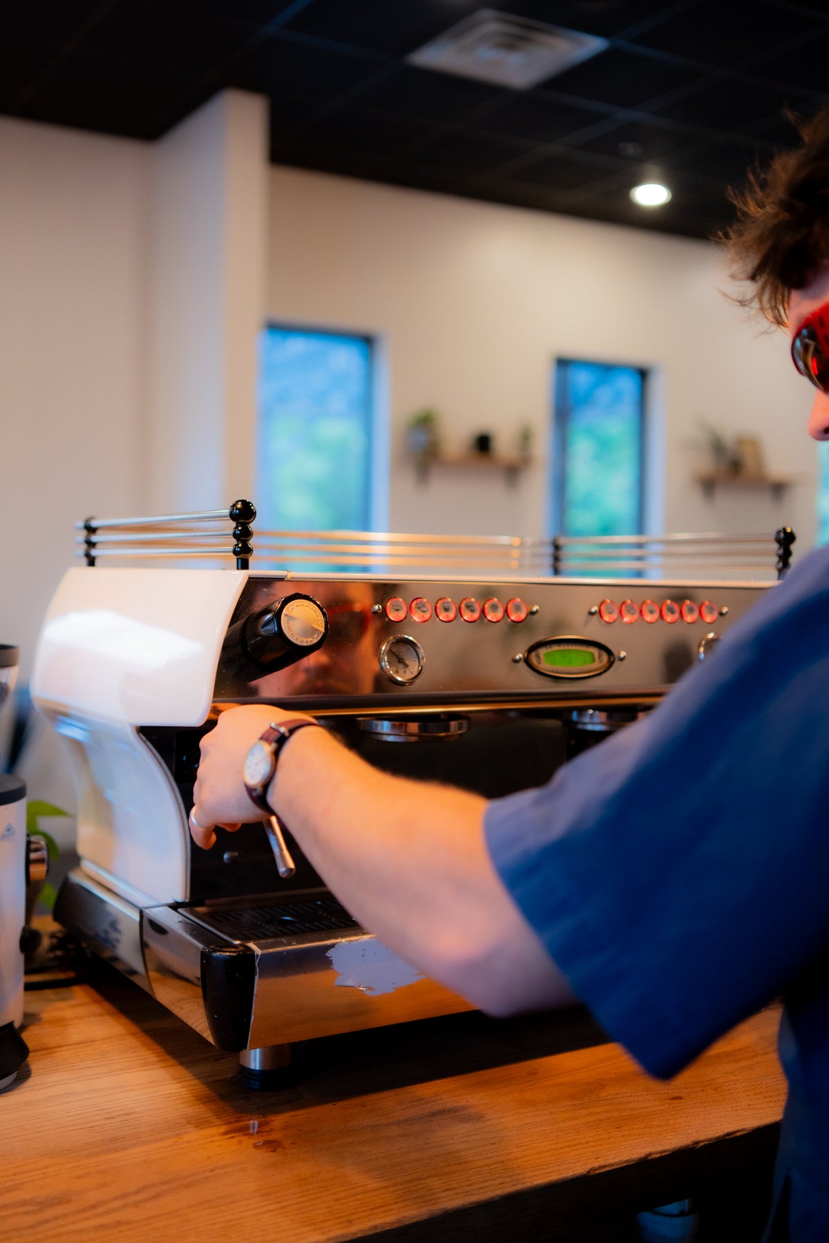 Technician working on a white espresso machine in a cafe