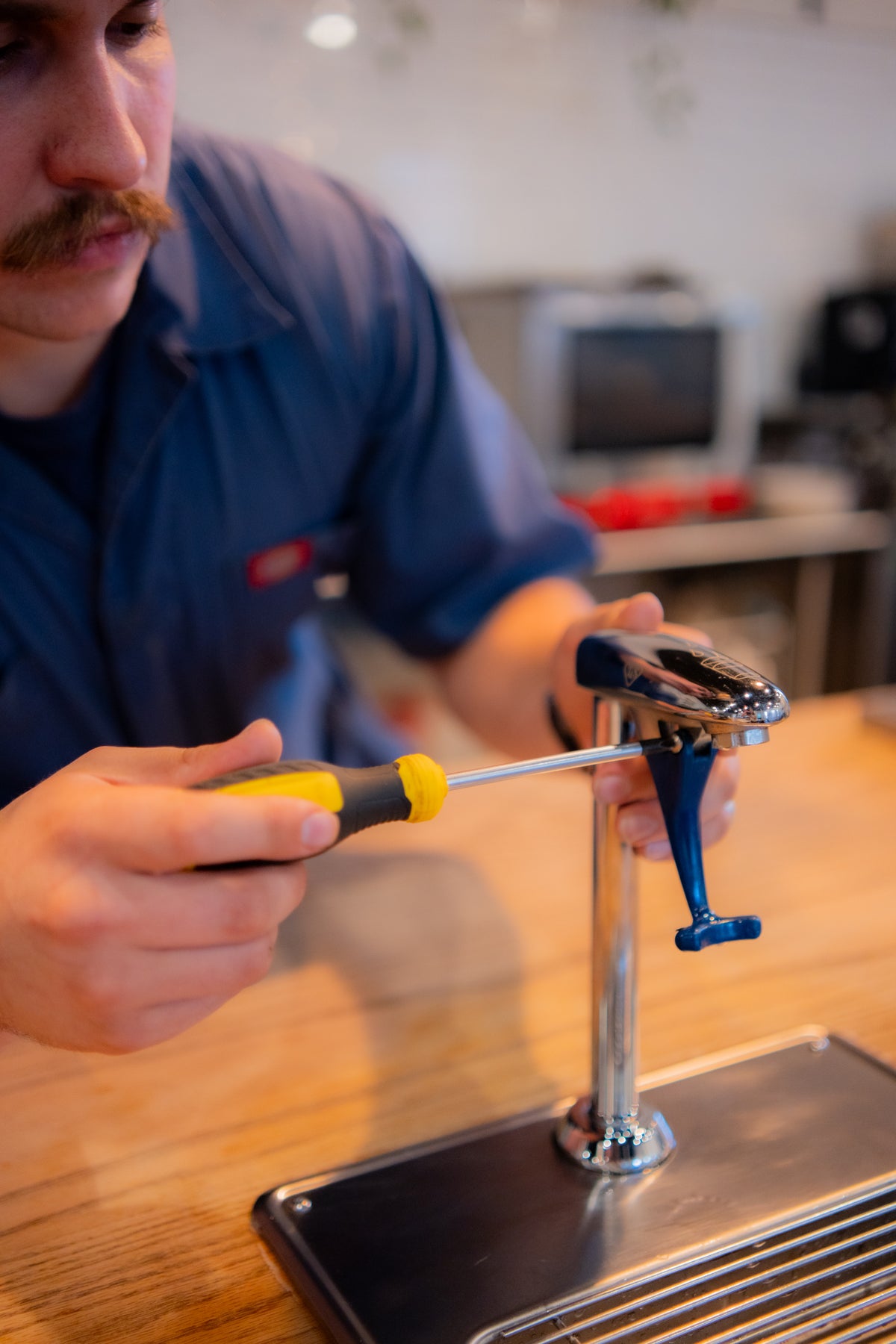 Coffee technician fixing a water filtration system on top of coffee bar