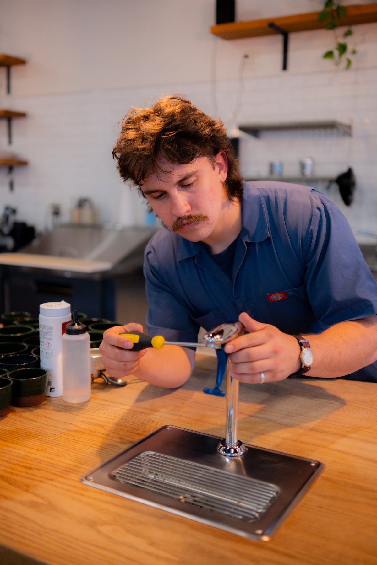 Coffee technician servicing a water filtration system on top of coffee bar
